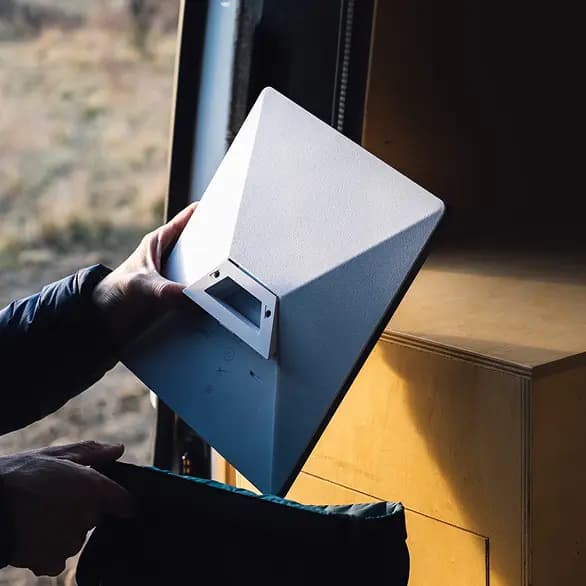 Person holding a Starlink satellite dish outdoors